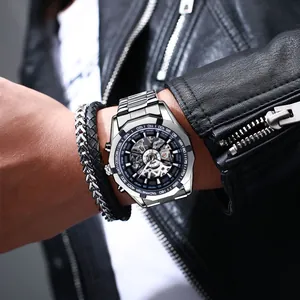 Nahaufnahme einer silbernen Skelett-Mechanikuhr mit Edelstahlarmband am Handgelenk
