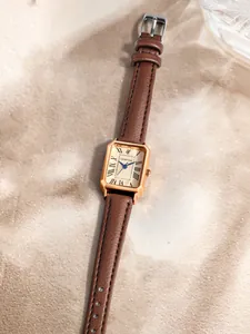 Détail d'une montre vintage rectangulaire pour femme avec bracelet en cuir marron