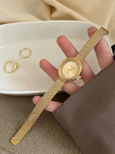 Detailed view of elegant gold quartz watch featuring a luxury woven metal bracelet