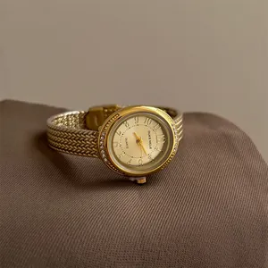 Elegant gold quartz watch with braided metal bracelet strap and rhinestone bezel detail
