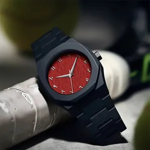 Nahaufnahme einer Herrenuhr mit strukturiertem rotem Zifferblatt und arabischen Ziffern.
