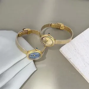 Detail view of luxury gold and blue dial quartz watches with elegant fine mesh metal straps.
