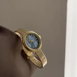 Elegant gold woven bracelet quartz watch with textured blue marble dial and crystals.