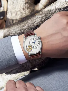 Primo piano dell'orologio al quarzo TOMI da uomo con cinturino in pelle marrone al polso