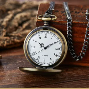 Detailansicht einer antiken Bronze-Taschenuhr mit weißem Zifferblatt und römischen Zahlen