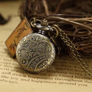 Close-up of vintage bronze pocket watch with carved floral lid and Drink Me tag charm