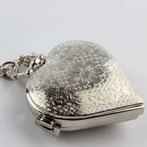 Primer plano detallado de un reloj de bolsillo vintage con forma de corazón de plata