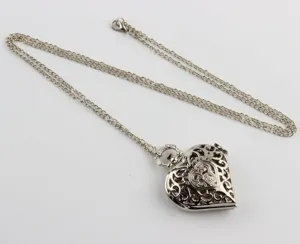 Vista detallada de un reloj de bolsillo vintage en forma de corazón plateado