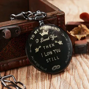 Detailopname van een vintage zwart zakhorloge met de gegraveerde tekst 'To My Husband' erop