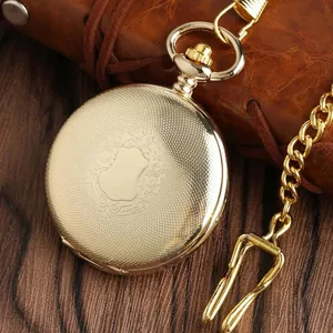 Dettaglio di un orologio da taschino meccanico dorato vintage con incisioni fini