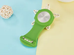 Macro detail showing the stainless steel back and safety pin of the green nurse watch.