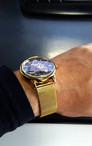 Nahaufnahme der goldenen Forsining Skelett-Mechanikuhr mit Mesh-Armband am Handgelenk