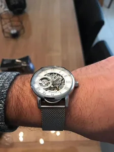 Nahaufnahme der Forsining Herren-Skelett-Mechanikuhr mit silbernem Mesh-Armband am Gelenk.
