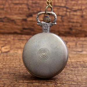 Macro detail view showing the engraved sunburst pattern on a vintage bronze pocket watch