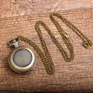 Close-up detail of a vintage bronze DIY pocket watch necklace on a wooden background