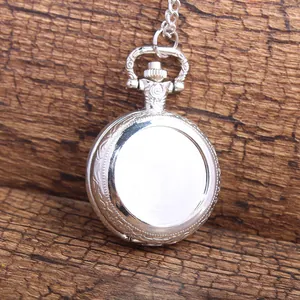 Detailed back view of a vintage silver pocket watch with embossed texture on wood.