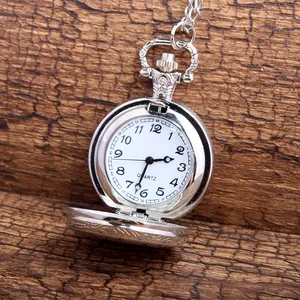 Detailed close-up view of a vintage silver quartz pocket watch with an open lid on wood.