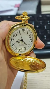 Primer plano de un reloj de bolsillo vintage dorado abierto con esfera de números árabes