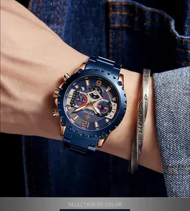 Detailopname van WWOOR blauw en goud chronograaf horloge gedragen met spijkerjasje