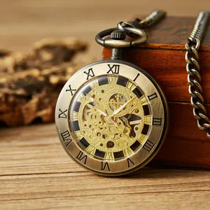Detalle de reloj de bolsillo esqueleto en bronce con engranajes dorados y números romanos.