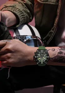 Gedetailleerd overzicht van MEGIR heren sport horloge met groene siliconen band op getatoeëerde arm