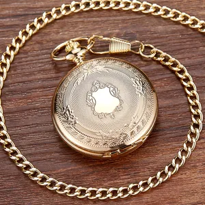Vista detallada de un reloj de bolsillo mecánico vintage dorado con grabados florales.