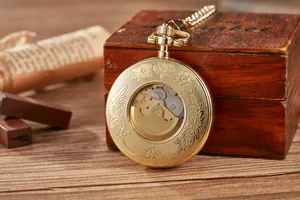 Intricate detail of a vintage gold skeleton mechanical pocket watch with floral engraving.
