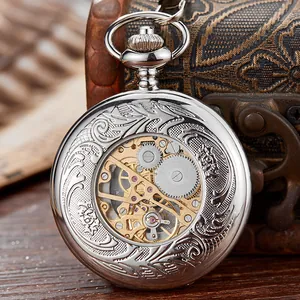 Primer plano de un reloj de bolsillo mecánico vintage con grabados florales