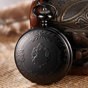 Primer plano de reloj de bolsillo vintage negro con grabados florales sobre cofre.