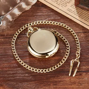 Close-up of a vintage polished gold mechanical pocket watch with a matching curb chain