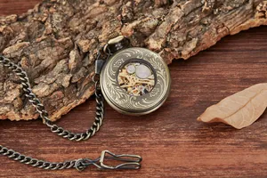 Detailed close-up of a vintage mechanical pocket watch with engraved hollow pattern