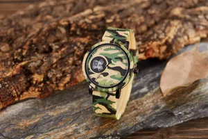 Close-up of camouflage sports watch with dual display and silicone strap on rock