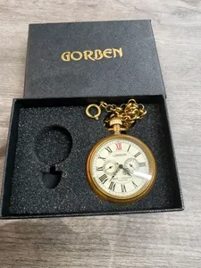 Vista detallada de reloj de bolsillo vintage de latón con números romanos y cadena