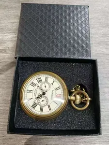 Primer plano de un reloj de bolsillo mecánico de latón con números romanos en un estuche