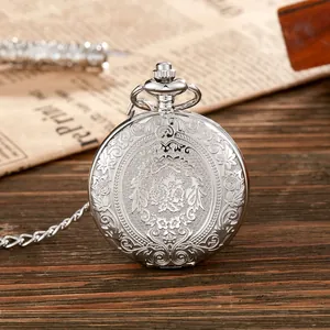 Detailopname van een vintage zilveren zakhorloge met een ingewikkeld gegraveerd bloemendeksel