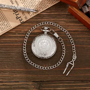 Gedetailleerde opname van de fijne bloemengravure op een vintage zilveren zakhorloge.