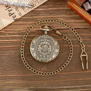 Detailopname van bronzen zakhorloge met gedetailleerd bloemig snijwerk op de deksel