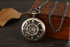 Nahaufnahme einer mechanischen Taschenuhr aus Bronze mit Steuerrad-Hohlraum-Design-Detail.