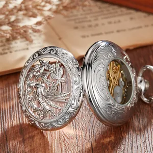 Close-up of vintage silver pocket watch with intricate bird and flower hollowed design