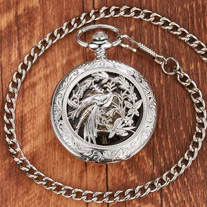 Close-up of vintage silver mechanical pocket watch with bird and flower hollow-out cover