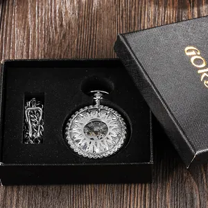 Close-up of a silver mechanical pocket watch with hollowed sun pattern in a black gift box.