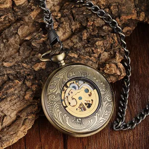 Vintage bronze automatic skeleton pocket watch with intricate floral engraving on wood
