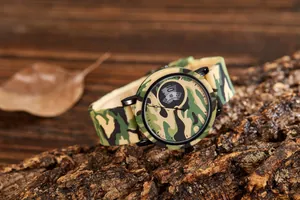 Close-up of trendy camouflage sports watch with silicone strap resting on rustic tree bark.