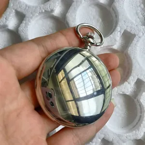 Dettagliato primo piano di un orologio da taschino meccanico lucido argento a specchio.