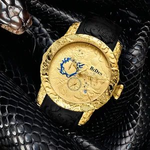Detail van gouden herenhorloge met 3D drakenreliëf en zwarte rubberen horlogeband
