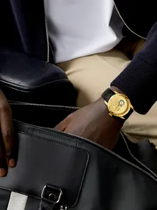 Detail van gouden herenhorloge met 3D-draakontwerp om de pols in een luxe setting.