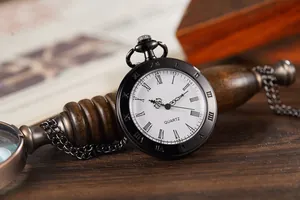 Close-up of vintage black quartz pocket watch with white Roman numeral dial