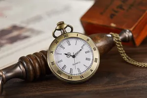 Macro detail of vintage bronze quartz pocket watch with open face white dial and Roman numerals