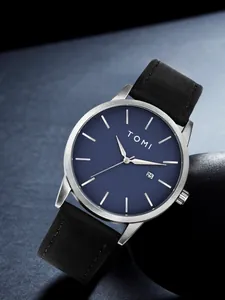 Gros plan de la montre minimaliste TOMI dotée d'un cadran bleu et bracelet noir