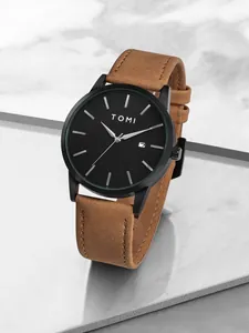 Gros plan sur la montre minimaliste TOMI avec cadran noir et bracelet en daim marron